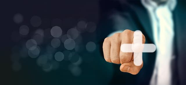 スーツを着たビジネスパーソンが指差しをしている